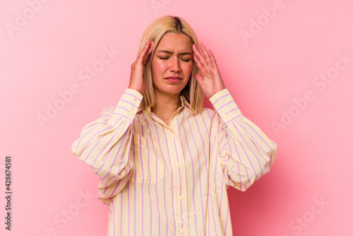 Young venezuelan woman isolated on pink background touching temples and having headache.
