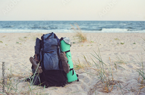 Tourist backpack and equipment on the sandy beach © Igor Luschay