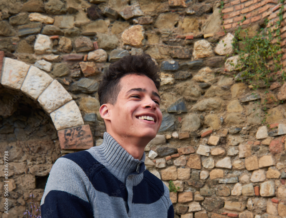 A handsome young cheerful Hispanic guy wearing a sweater A handsome young cheerful Hispanic guy wearing a sweater