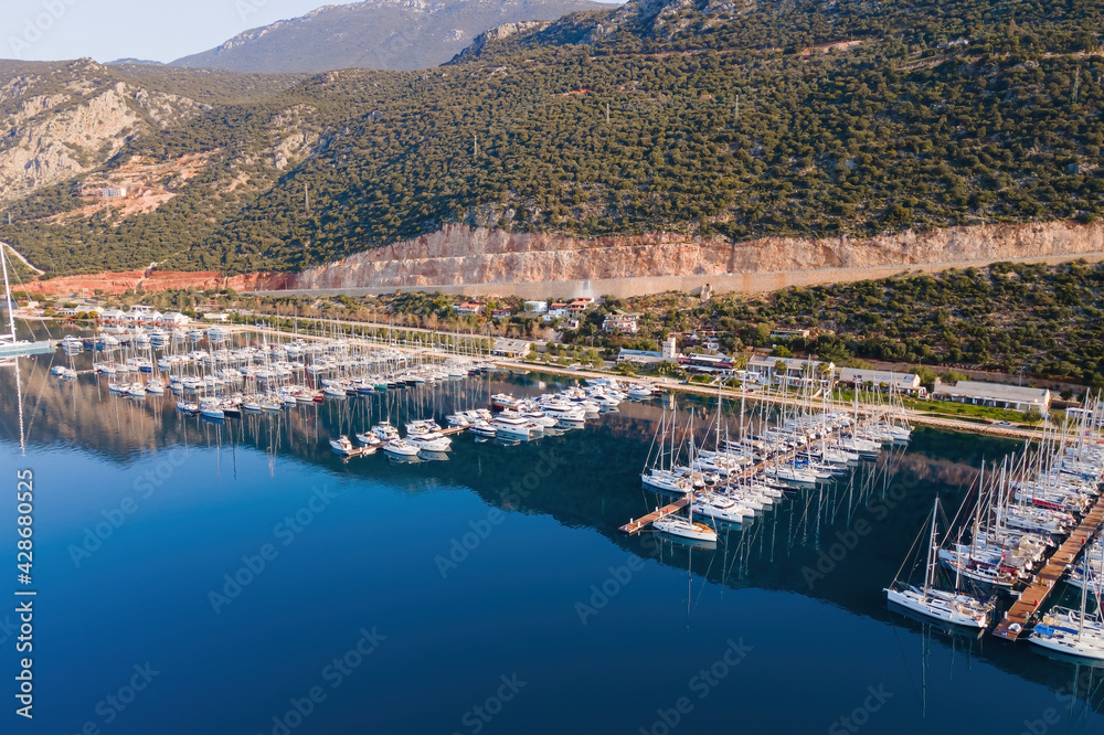 Obraz premium Aerial view of city marina or port with yachts and boats docked on a calm warm summer morning.