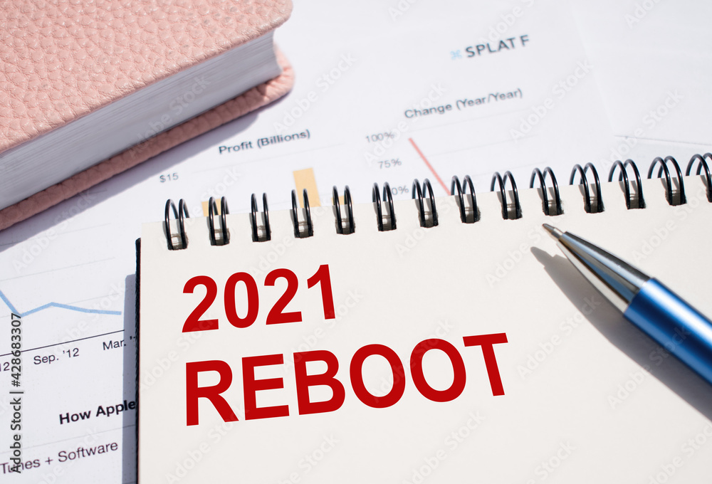 Symbol of 2021 reboot. The text written on notepad with pen on financial documents