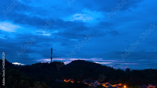 Cinematic Timelapse footage circle view of 5G Communication tower during morning sunrise with clouds, mists and fog