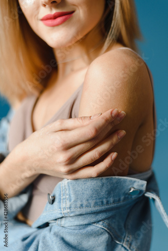 A lovely blonde in a denim jacket gently touches her body. Natural real beauty concept. Trending photo