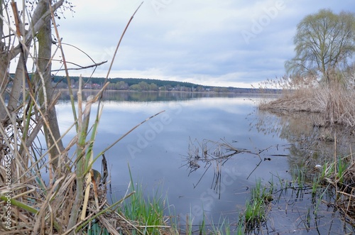 A beautiful endless lake in the late afternoon. The lake displays the sky like a mirror. Mirror-like clear water. Magic view of the lake in the evening. Fabulous nature. 