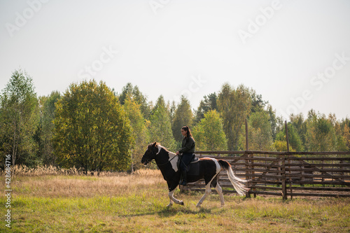 Cute girl-rider rides her fast horse on the territory of the ranch © Anna Kosolapova