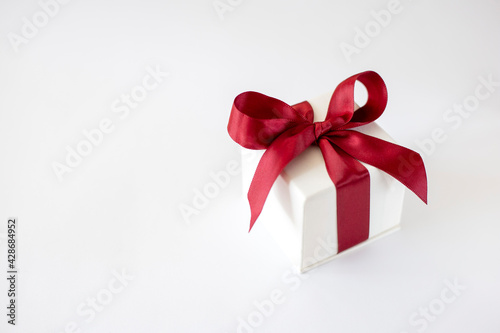 White box with a red bow on a white background. Gift concept © Oksana