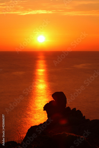 Sunrise with natural red granite sculptures as silhouettes