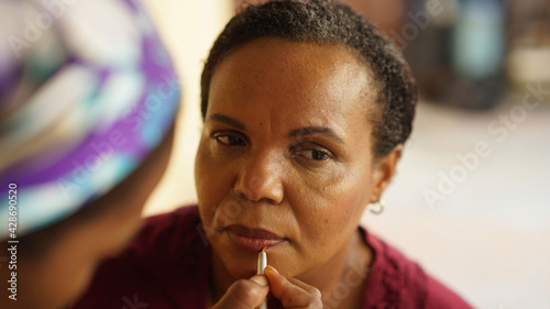 Black woman getting makeup done