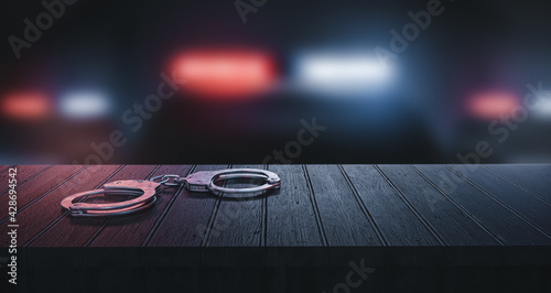 handcuff on the table, background with police officers 3d rendering
