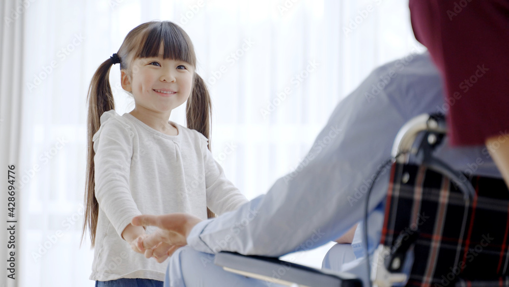Fototapeta premium 車椅子に乗ったおじいちゃんと孫娘