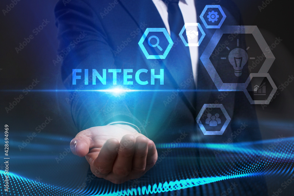 Business, Technology, Internet and network concept. Young businessman working on a virtual screen of the future and sees the inscription: Fintech Business, Technology, Internet and network concept. Young businessman working on a virtual screen of the future and sees the inscription: Fintech