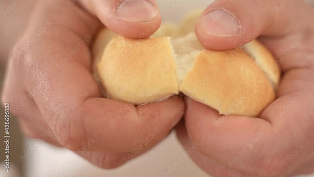 Breaking Kaiser Bread Open by Hands, Slow Motion Close Up with Copy Space Breaking Kaiser Bread Open by Hands, Slow Motion Close Up with Copy Space