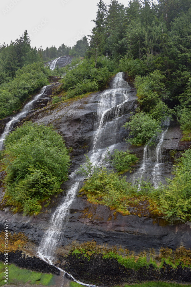 A triple waterfall cascades down a mountainside in the Misty Fjords National Monument in Alaska.