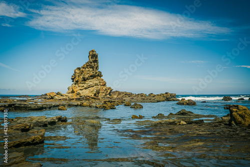 Eagles Nest rock formation with reflection on scenic ocean coastline