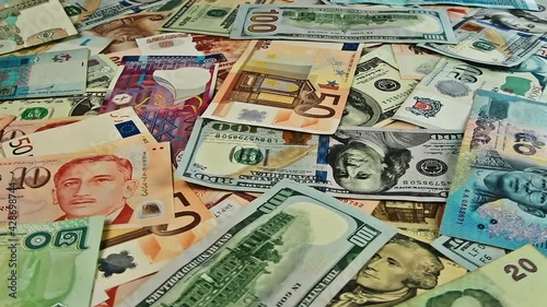 Cash money background closeup rotation. US dollar, euro, ruble, baht, peso, rupee banknotes