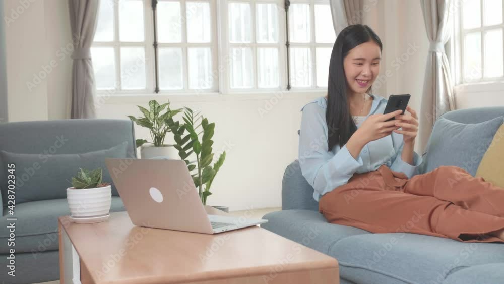 Asian Female Use Mobile Phone In Living Room While Lying On Sofa Asian Female Use Mobile Phone In Living Room While Lying On Sofa
