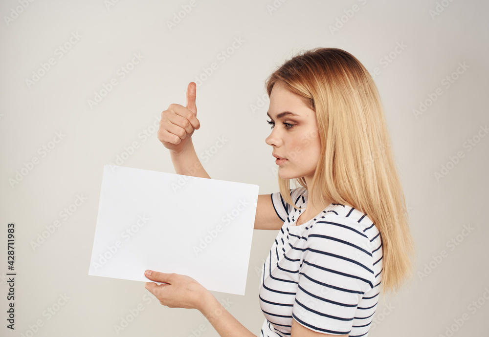 Naklejka premium Woman gestures with her hands on a beige background of emotions and a white sheet of paper