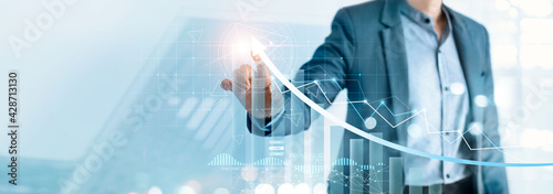 Businessman pointing arrow graph growth and financial network connection, analysing data to increase sales and revenue profit to achieve business investment goal in global economic situation.