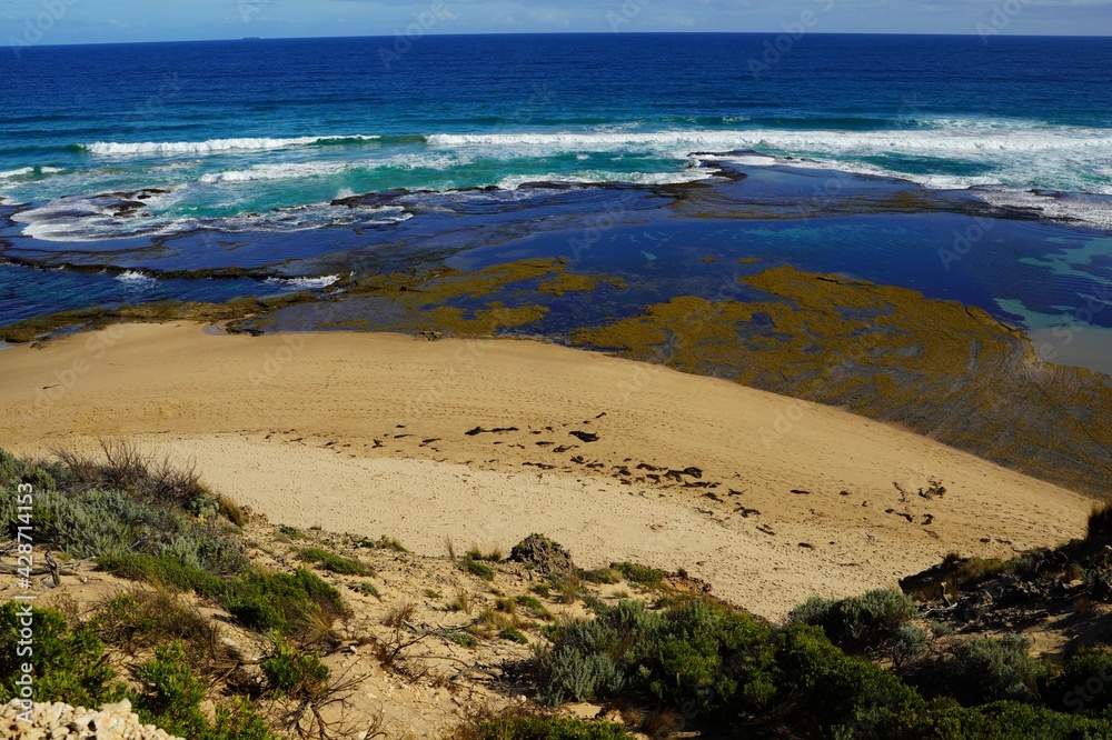 Obraz premium Sandstone by the beach under blue sky