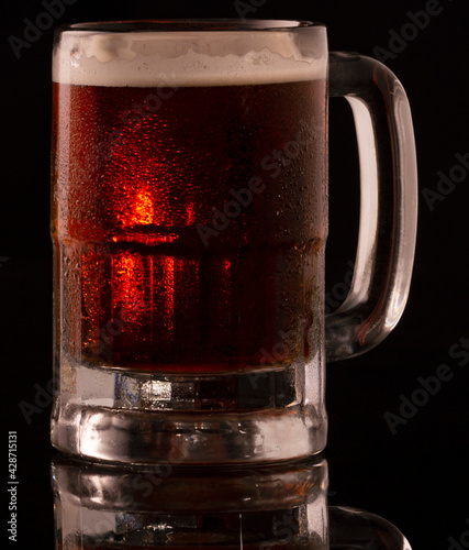 Cerveza obscura en tarro con goyas de agua photo