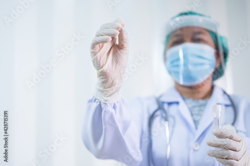 Doctor taking a swab for corona virus sample from potentially infected Asian boy nose.Covid-19 laboratory test.Medical staff with PPE suit test coronavirus covid-19 by nose swab at hospital.