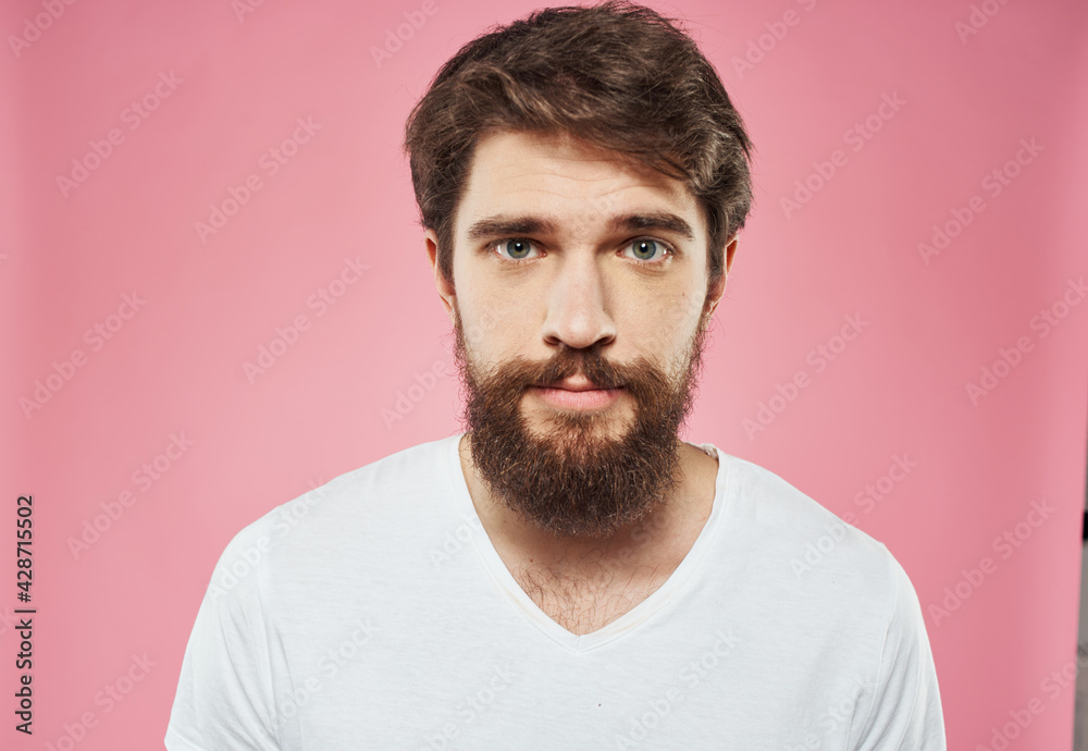 Fototapeta premium Man with a beard on a pink background sad face emotions model