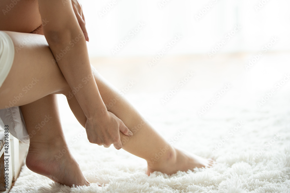 Asian women lag pain on bed in bed room in the morning. Asian women lag pain on bed in bed room in the morning.