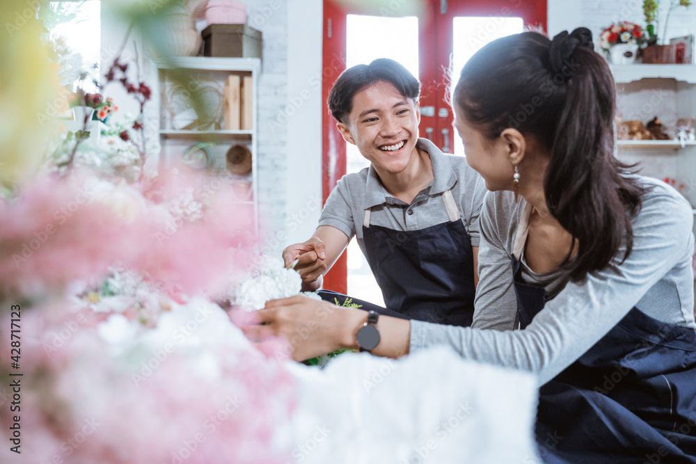 Samolepka portrait young couple wearing apron smiling talking while working together in fl