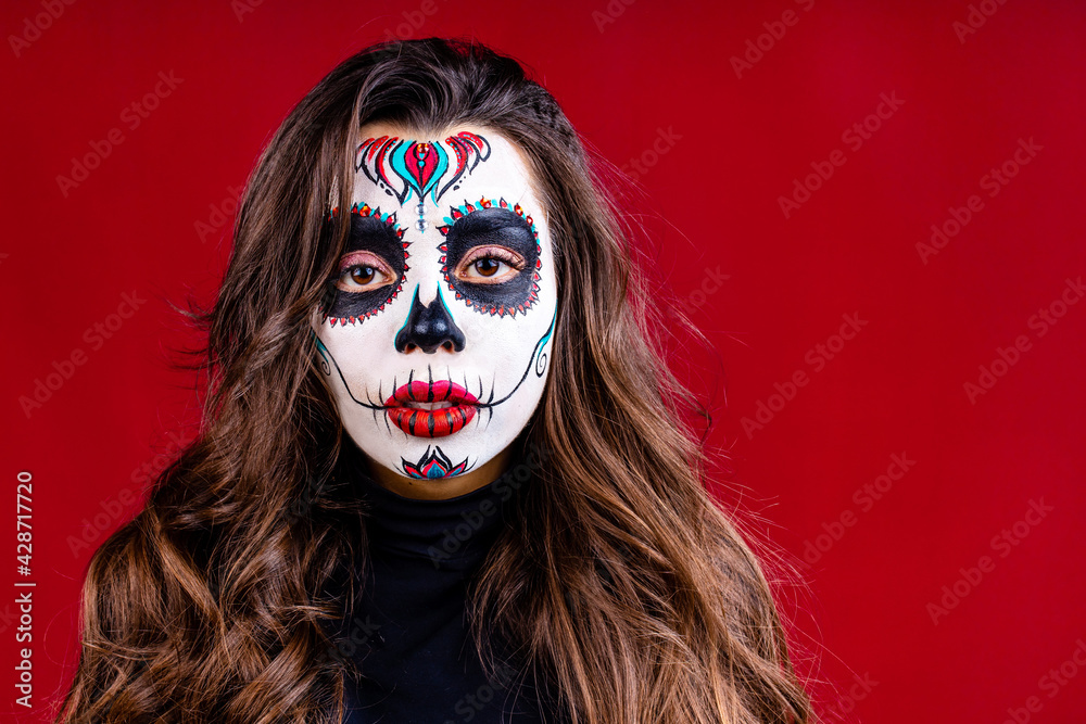 1st and 2nd november celebration of day of the dead in mexico concept woman with grimm skull face and black cloth in studio