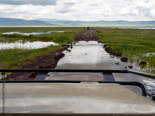 Ngorongoro Crater, Tanzania, Africa - March 1, 2020: Crossing flooded roads in jeep