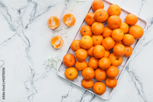 Tray with sweet tangerines on light background © Pixel-Shot