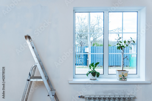 Quadro em tela Metal stepladder in room with plastered walls near window