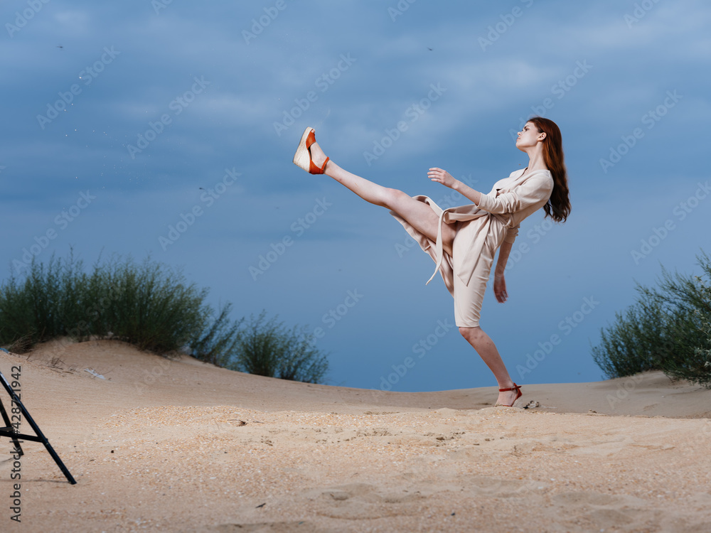 A woman in a beige dress walks with a long stride on the beach A woman in a beige dress walks with a long stride on the beach