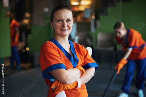 Pleased janitor posing for the camera during the office cleaning photo