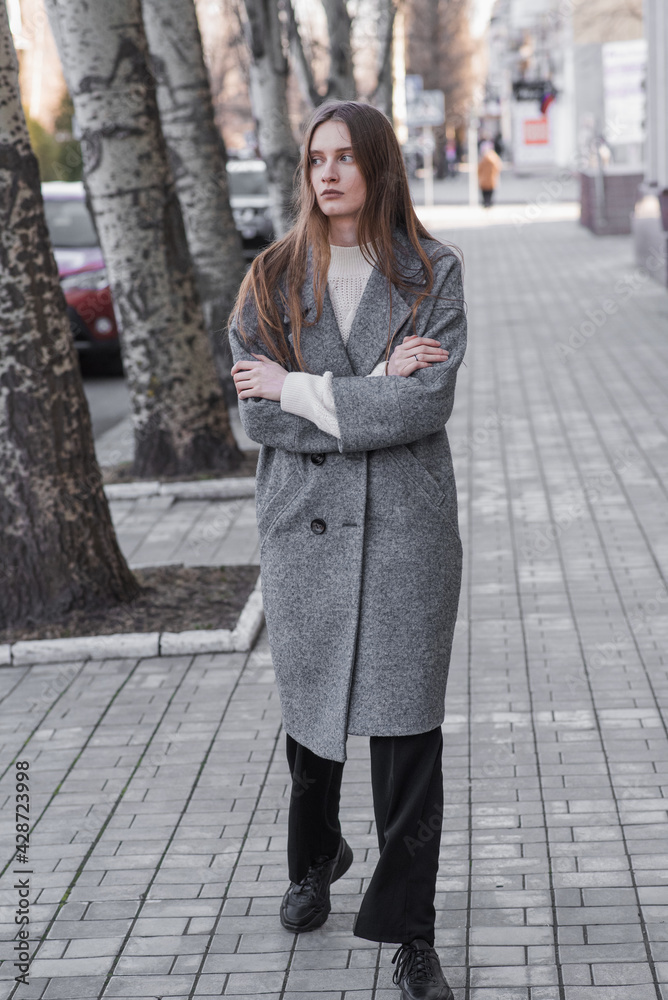 Fototapeta premium Portrait of an attractive girl on the street while walking