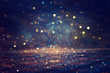 background of abstract glitter lights. gold, blue and black. de focused