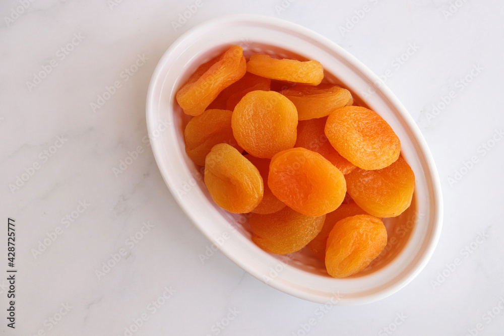Dried apricots on white background with copy space. sundried golden organic apricots. Dried apricots on white background with copy space. sundried golden organic apricots.