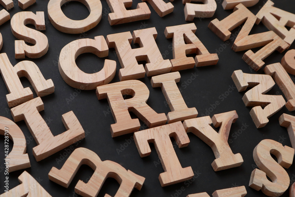 Charity, text words typography written with wooden letter on black background, life and business motivational inspirational Charity, text words typography written with wooden letter on black background, life and business motivational inspirational