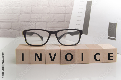 INVOICES word written on wood block. INVOICES text on wooden table for your desing, concept.