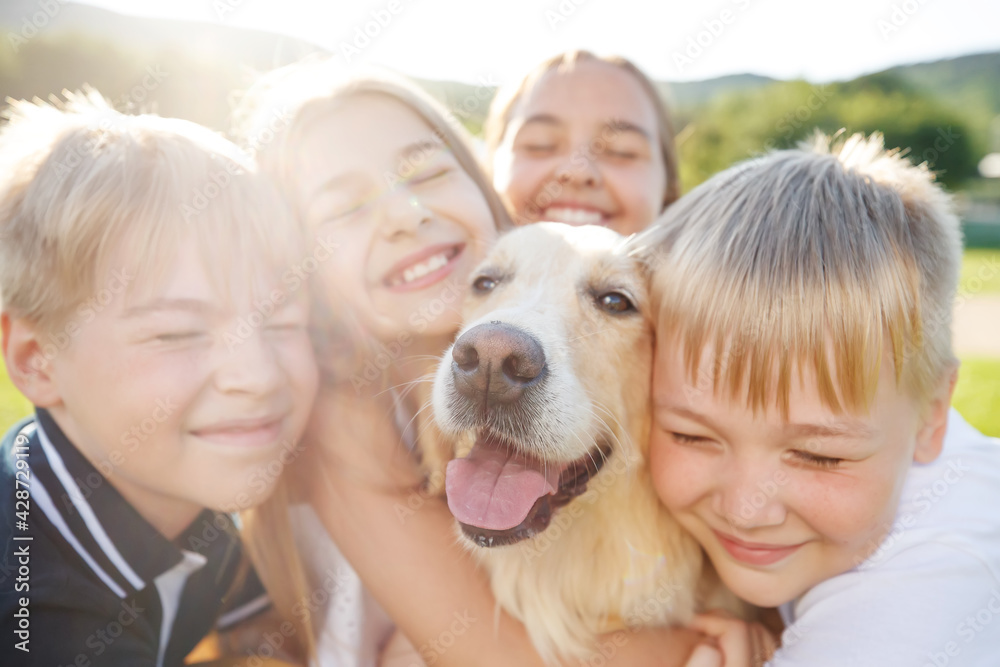 Group of happy children playing on green grass in a spring park with a dog. High quality photo. Group of happy children playing on green grass in a spring park with a dog. High quality photo.