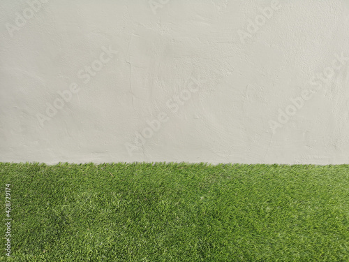 Abstract grunge and scratched technique grey color concrete wall, cement smooth surface material texture background and grass flooring