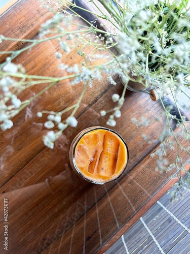 Top view Thai milk tea in glass on wood table. Cafe concept