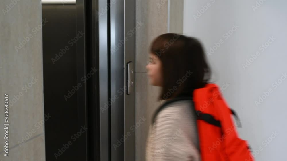 girl child schoolgirl 8 years old with an orange backpack goes into the elevator at home. High quality 4k footage girl child schoolgirl 8 years old with an orange backpack goes into the elevator at home. High quality 4k footage