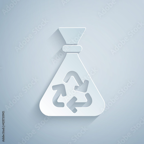 Paper cut Garbage bag with recycle symbol icon isolated on grey background. Trash can icon. Recycle basket sign. Paper art style. Vector