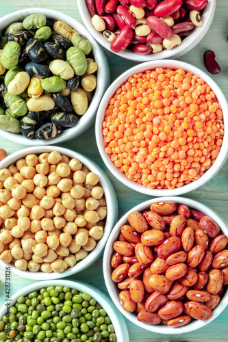 Legumes close-up. Many different pulses in bowls, overhead shot