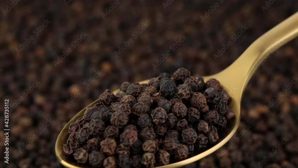 peppercorn in golden spoon and on black background. Flavorful and aromatic black pepper. 4K UHD video peppercorn in golden spoon and on black background. Flavorful and aromatic black pepper. 4K UHD video