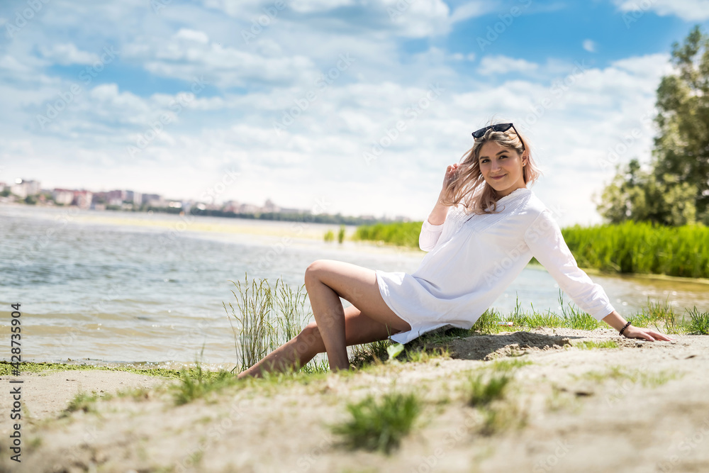  young beautiful woman in white dress enjoy nature near the lake, freedom