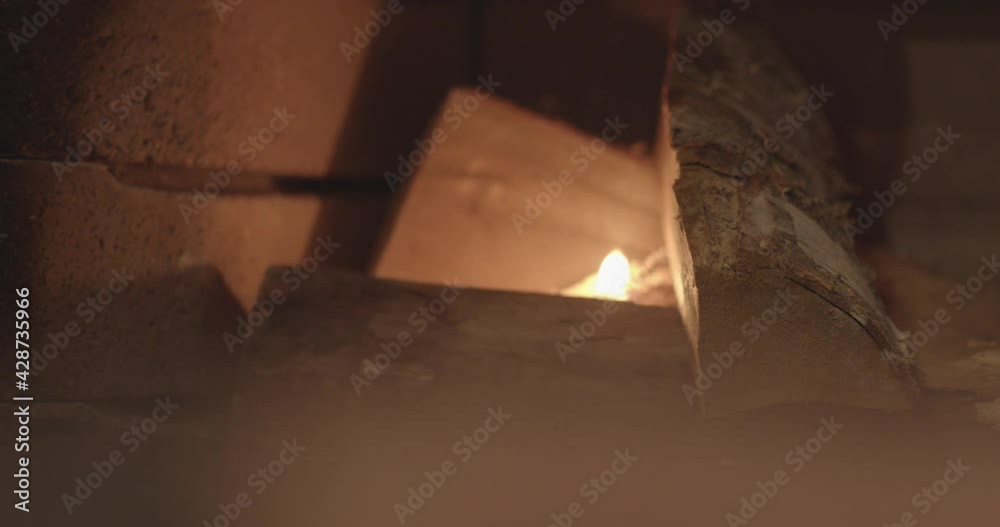 Closeup shot of a person lighting a fire surrounded with logs, inside a fireplace. Closeup shot of a person lighting a fire surrounded with logs, inside a fireplace.