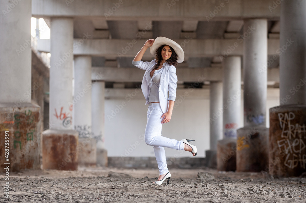 Young woman in white near concrete columns...