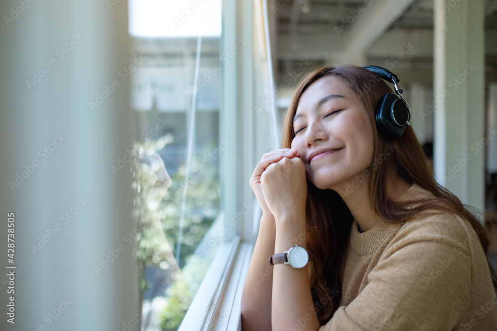 Portrait image of a beautiful young asian woman enjoy listening to music with headphone
